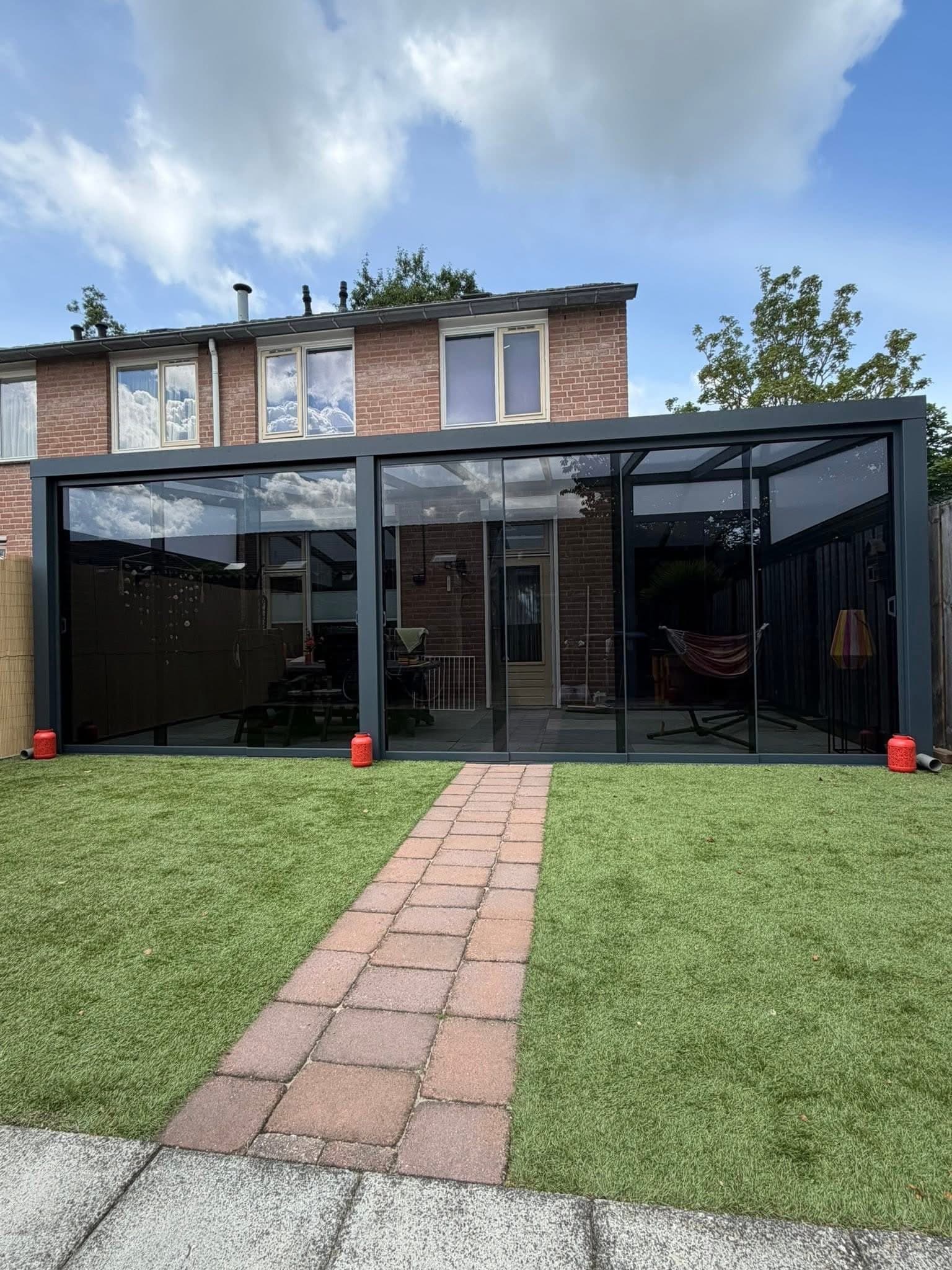 Veranda met glazen schuifwanden en tuinpad